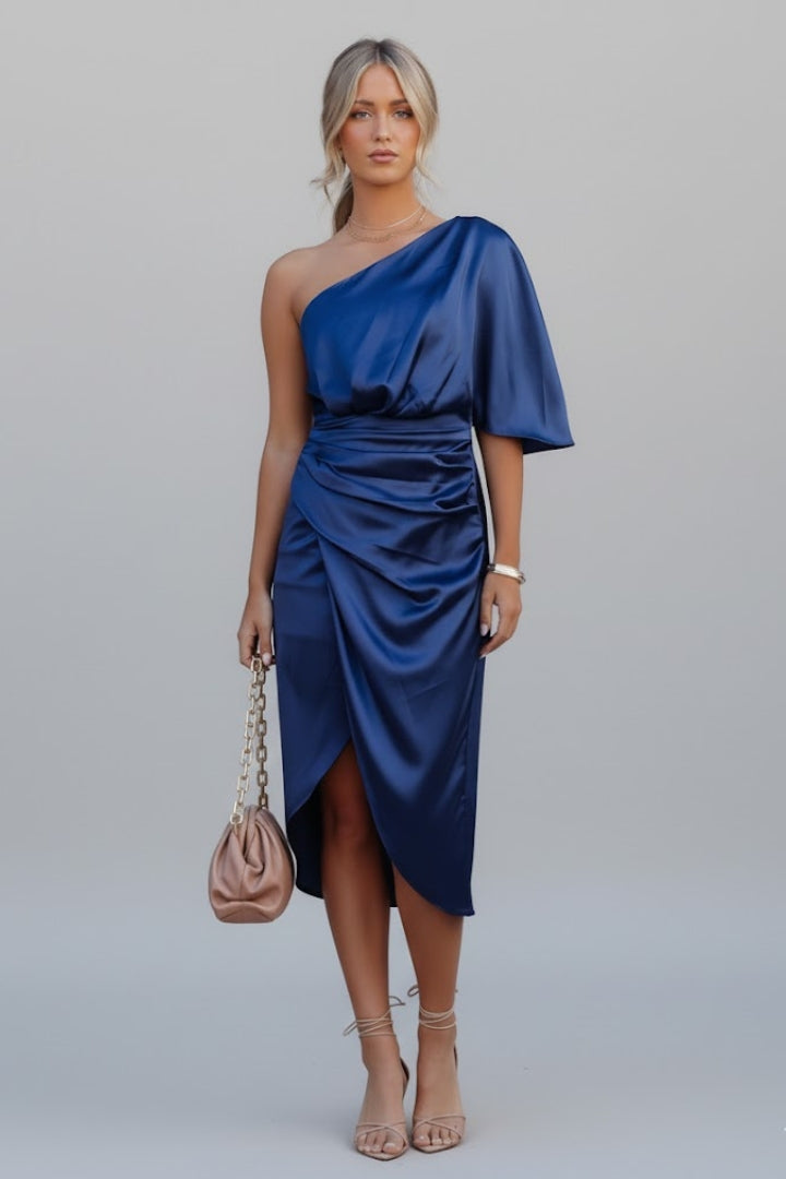Woman wearing elegant midi dress front view on plain gray background.
