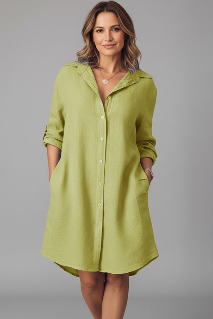  Woman displaying a long sleeve collared dress with side pocket details against a plain background.