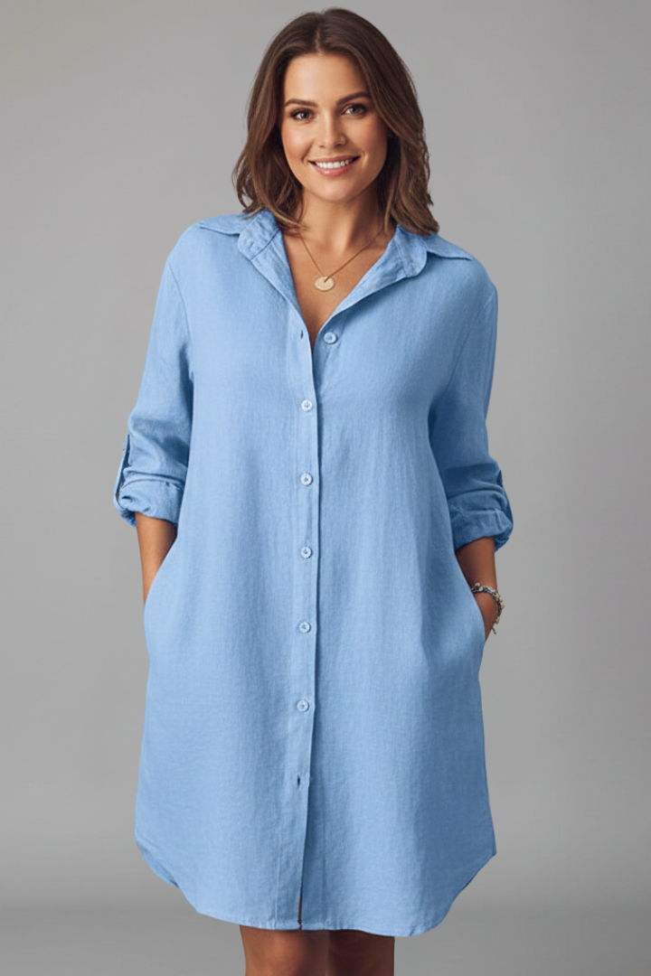 Female wearing a button front shirt dress with long sleeves and collar against a plain background.