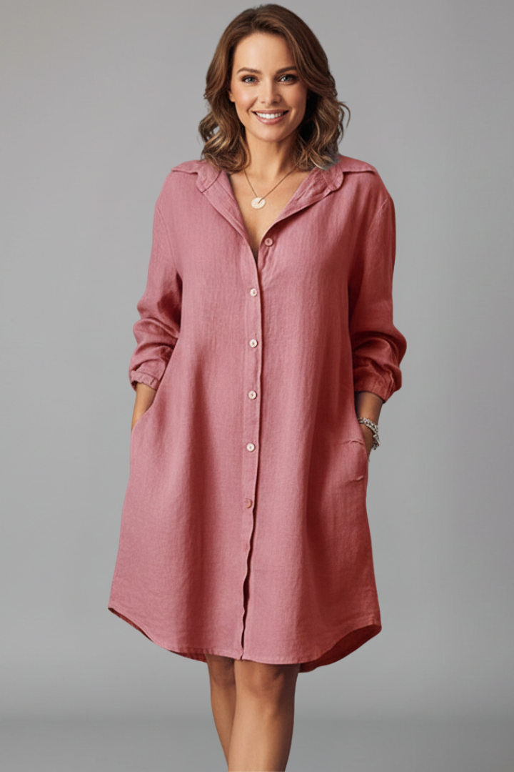 Female wearing a structured shirt dress with a full button front on a plain background.