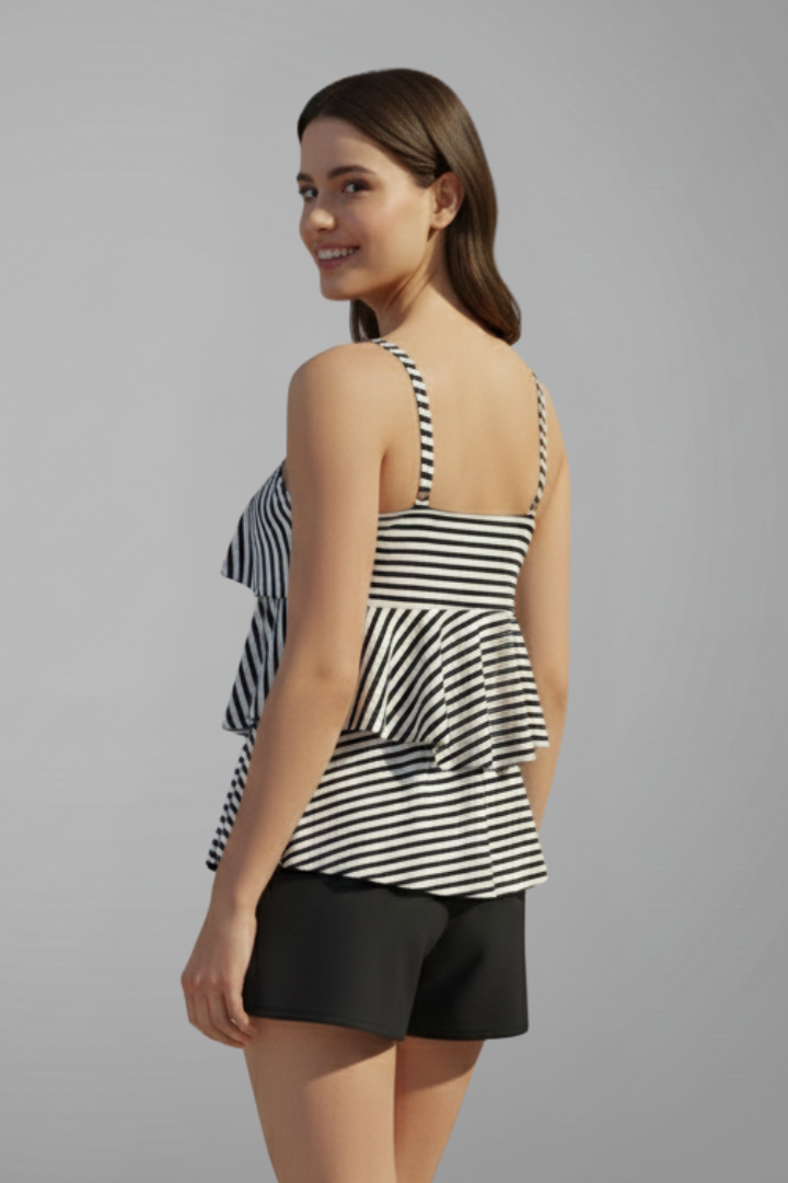 Woman posing back view striped tankini shorts, plain gray background