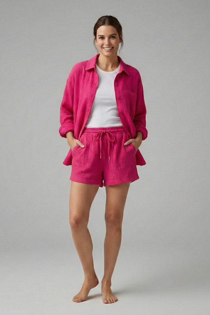 Female model wearing button shirt and shorts minimal gray background