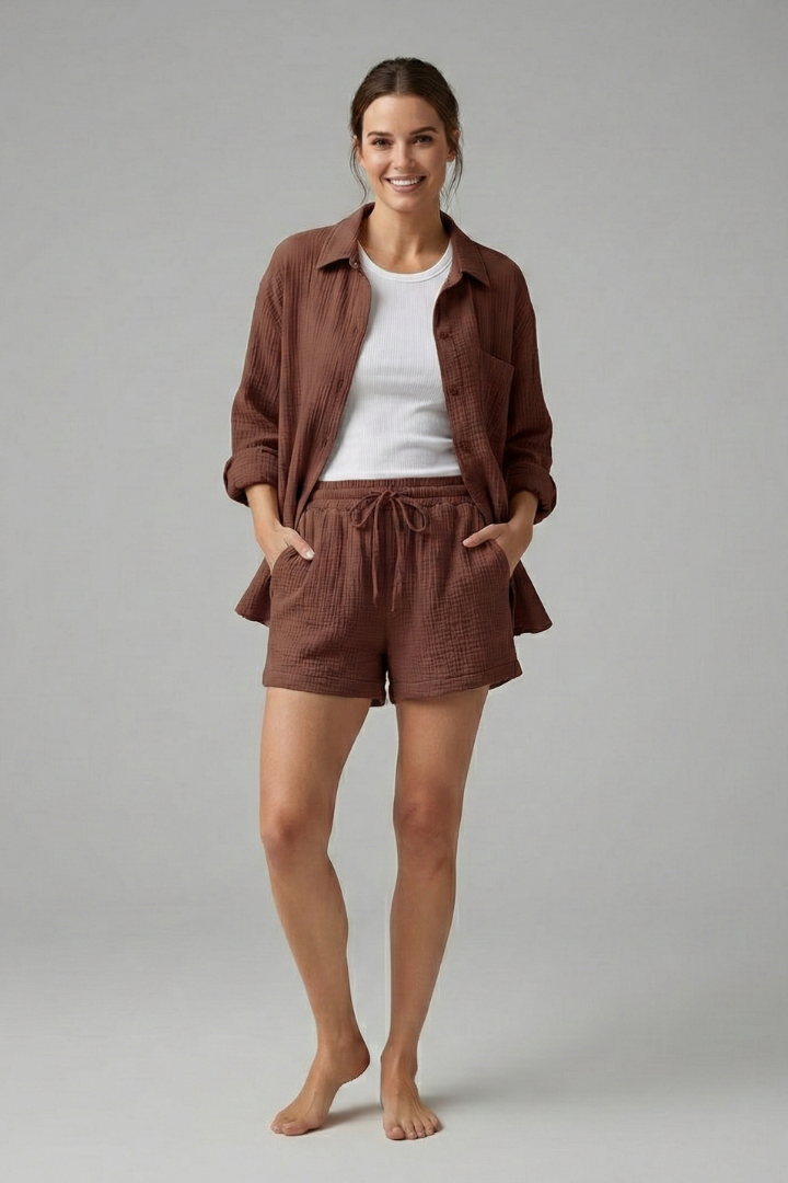 Female model minimal pose wearing coordinated outfit gray backdrop