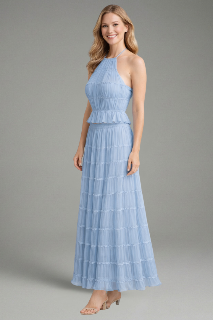 Model side angle blue set top and skirt on plain gray background