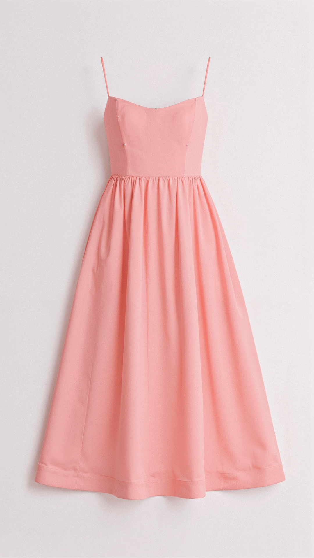 Female showcasing a versatile midi dress with delicate straps and fluid movement against a plain background.