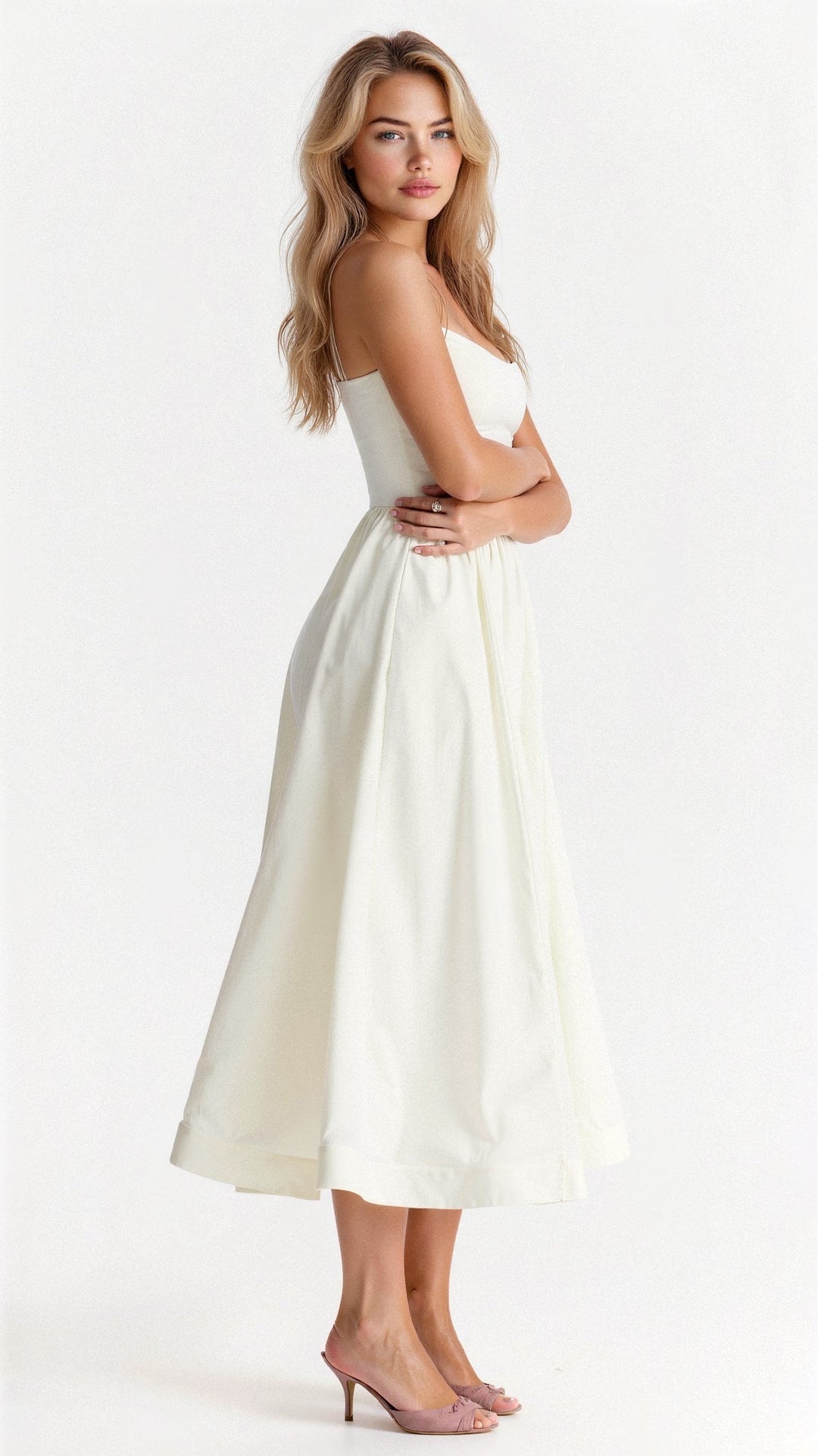 Woman showcasing a sleeveless midi dress with a relaxed flowing silhouette on a plain background.