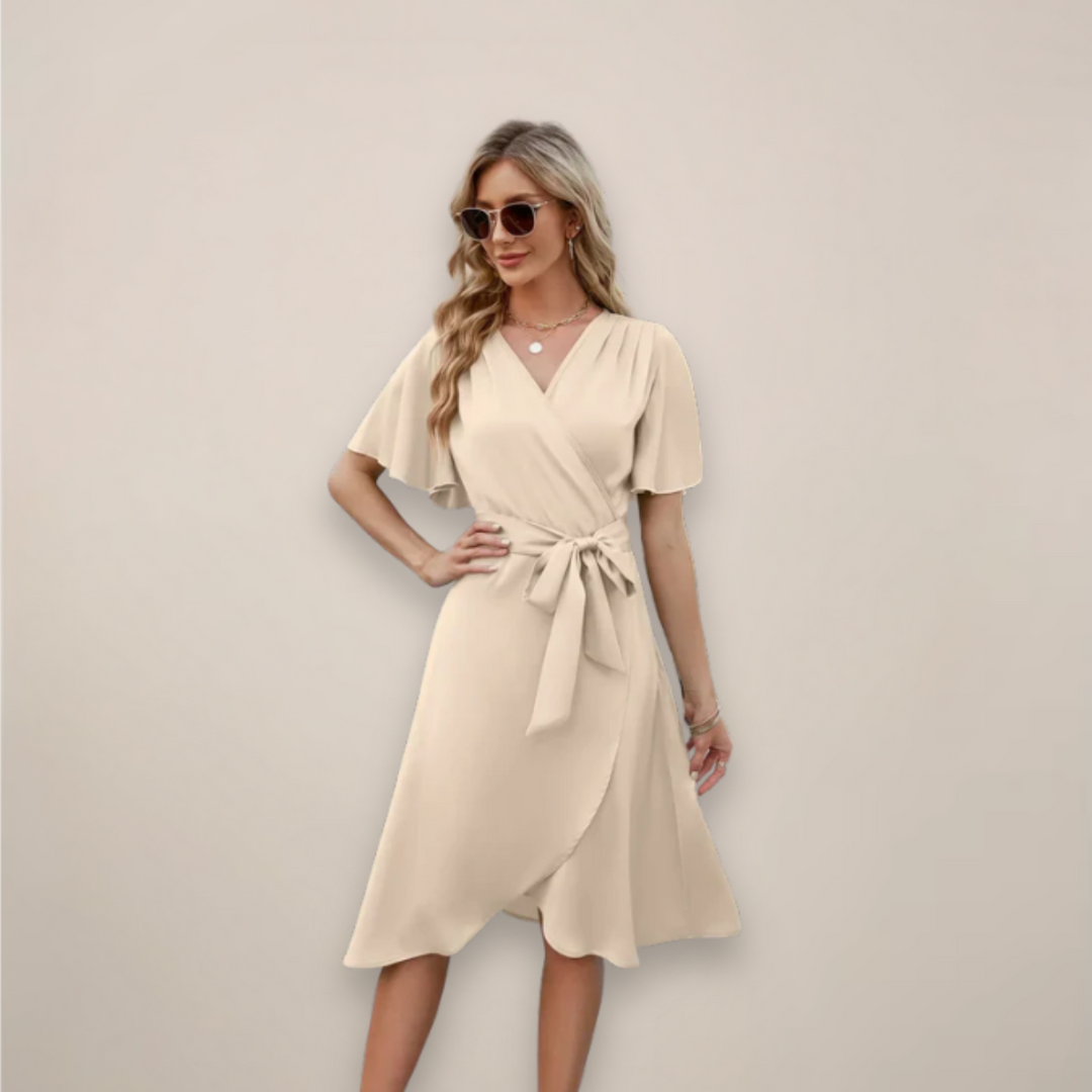 Female model wearing a V-neck midi dress with a graceful drape on a plain background.