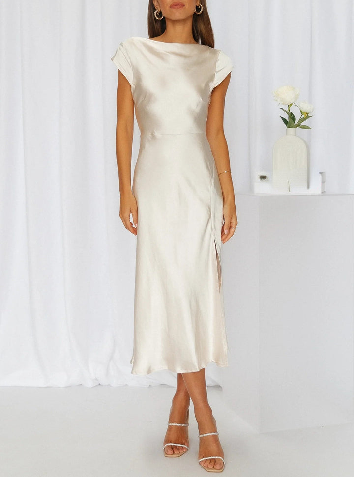 Model showcasing a batwing sleeve midi dress with a soft neckline and tailored skirt on a plain background.