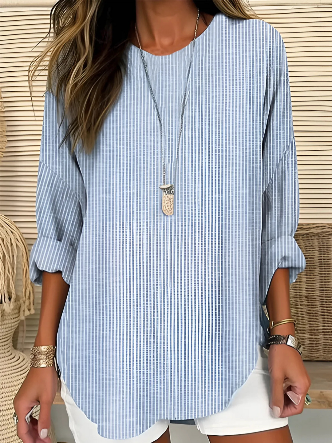 Striped women’s blouse displayed on a model against a plain background.