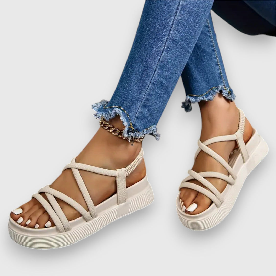 Female model showcasing casual women’s sandals with a simple background.