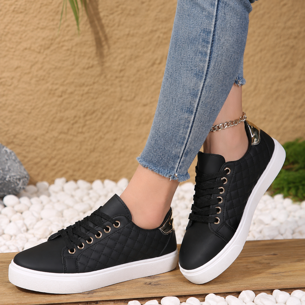 Stylish women’s walking shoes shown on female feet with plain background.