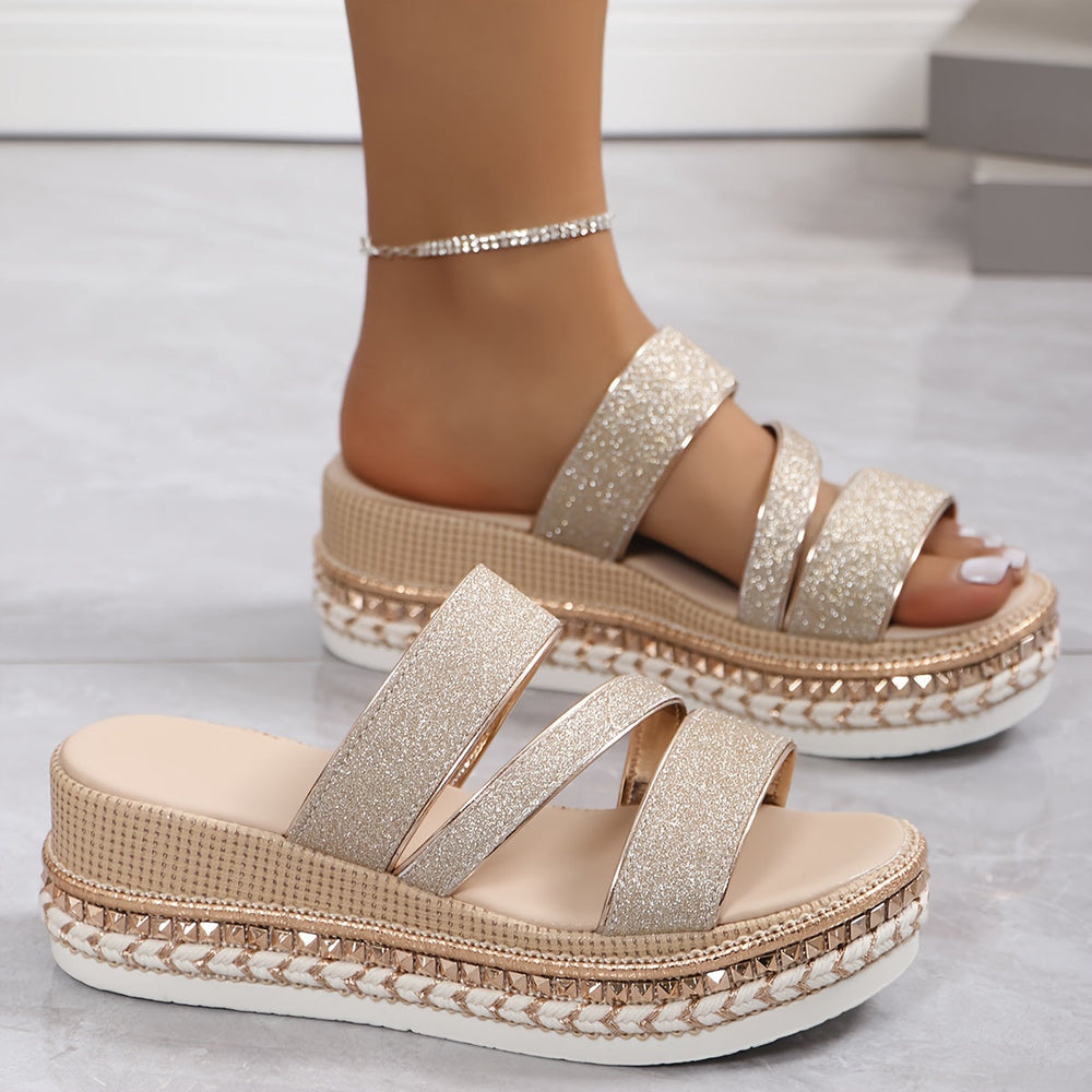 Female feet shown in glitter champagne sandals on a clean background.