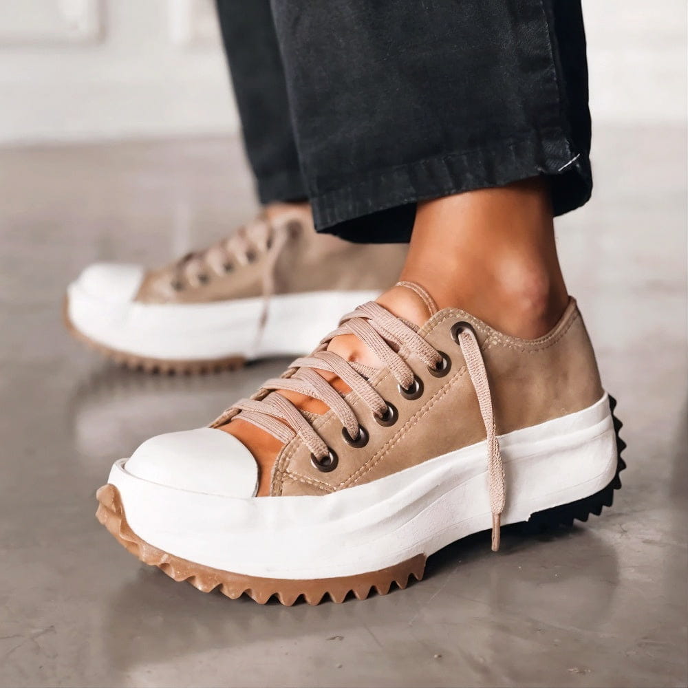 Woman wearing lightweight walking sneakers displayed against a plain background.