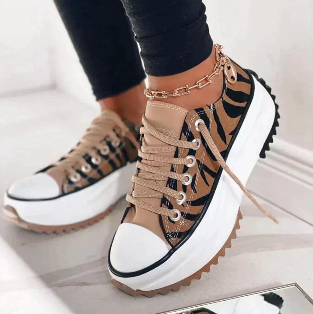 Women’s walking shoes displayed on female feet in a plain studio setting.