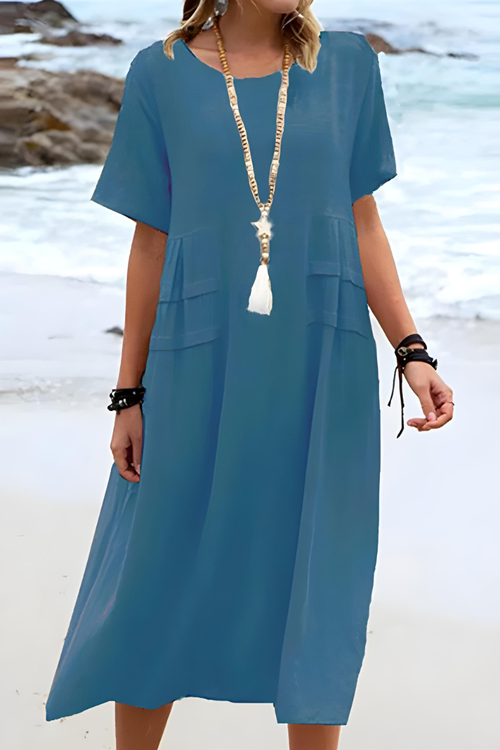  Female displaying a loose-fitting midi dress with a graceful drape on a plain background.