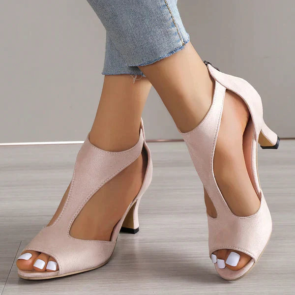 Women’s heeled comfort sandals on a plain background with adjustable straps and cushioned footbed.