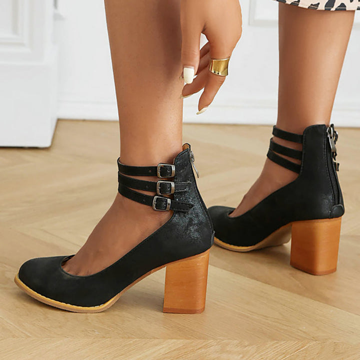 Foot shown in a polished ankle strap sandal with stable heel support.