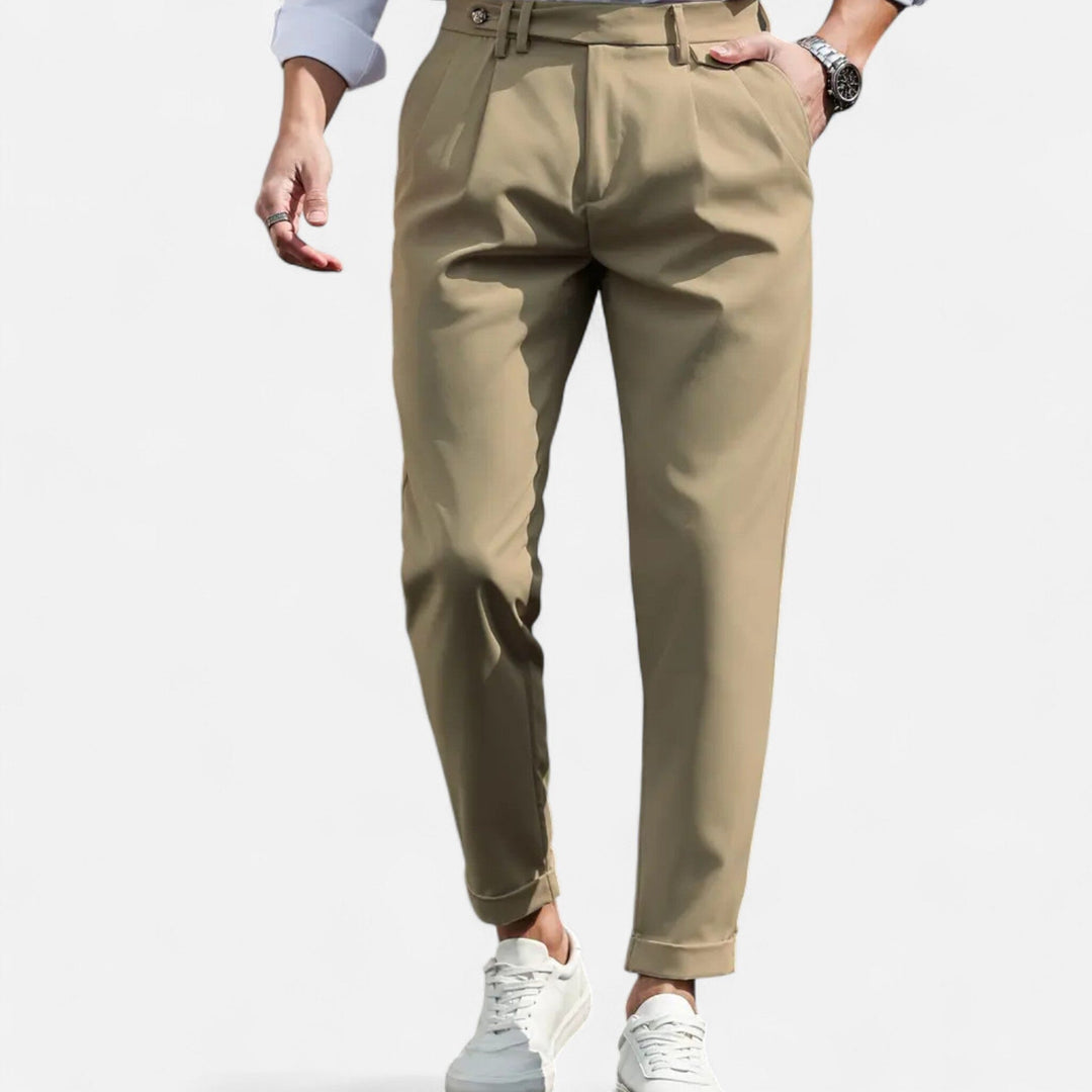 Male model wearing slim fit pleated trousers against a plain background.