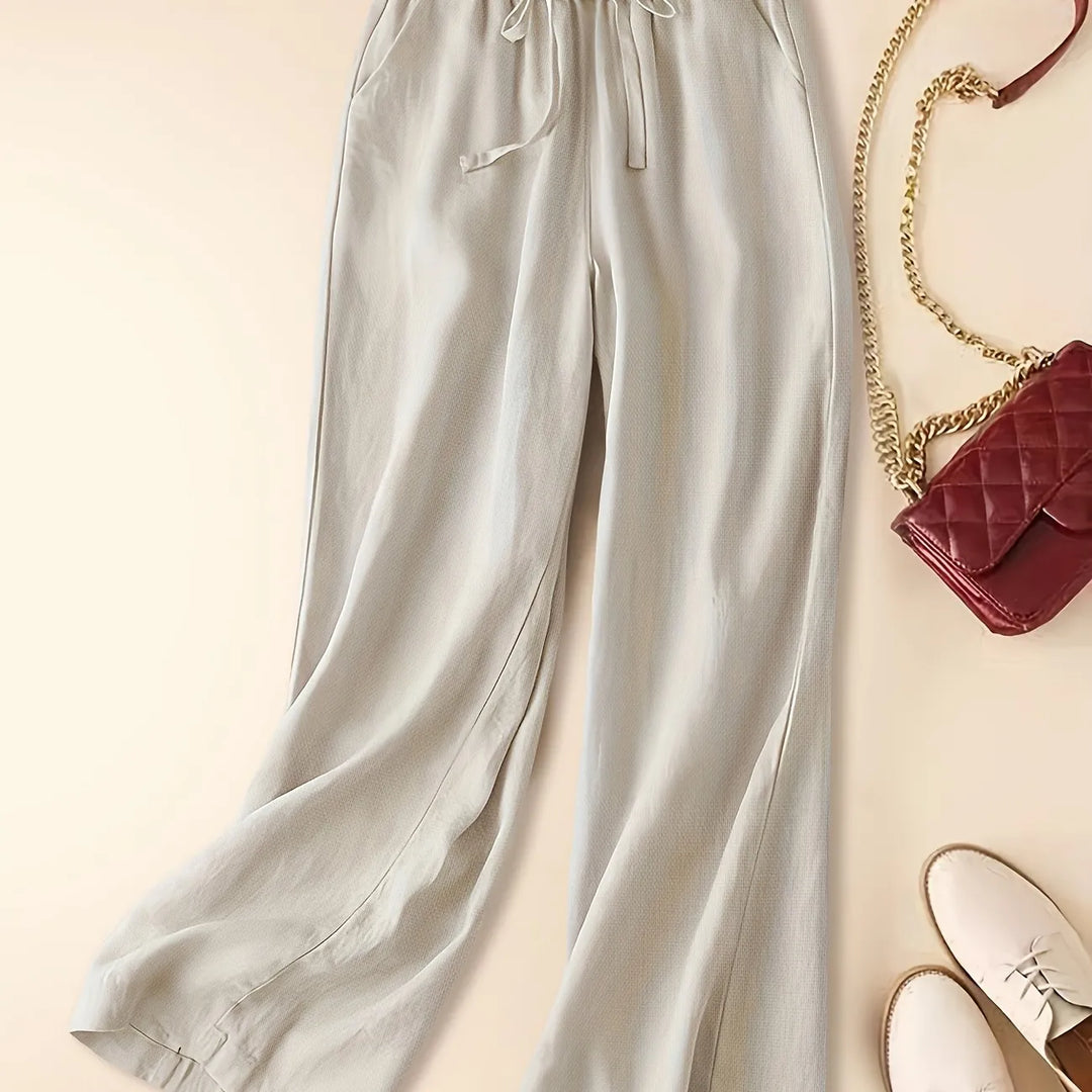 Relaxed women’s trousers with adjustable waist shown against a beige background.