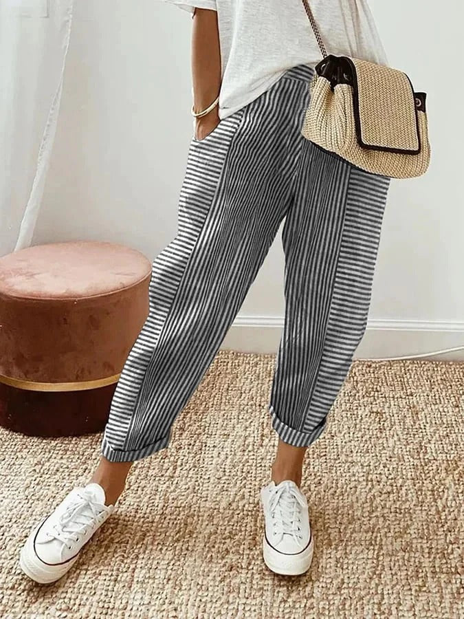 Woman styling striped wide-leg pants on a clean background.