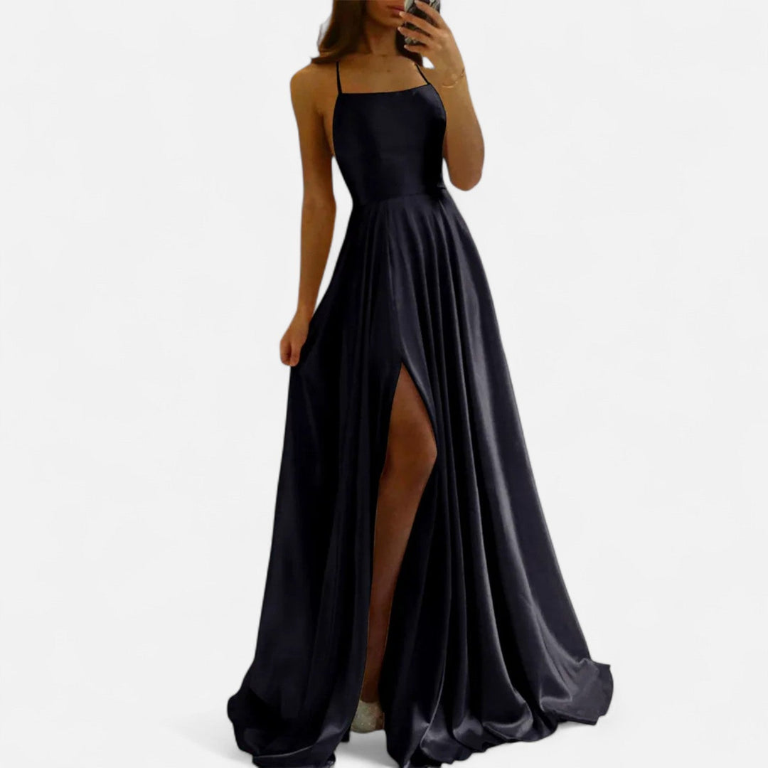 Woman showcasing back view of maxi dress on plain background.