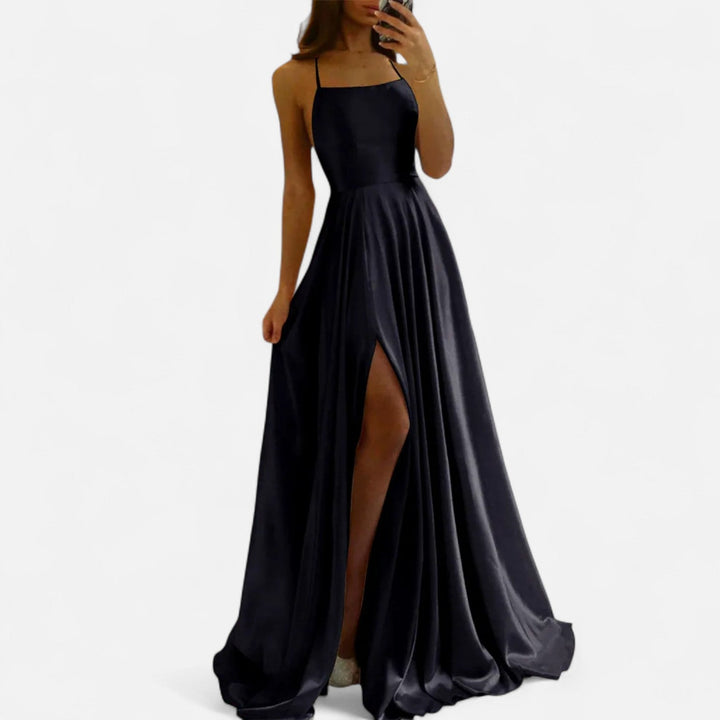 Woman showcasing back view of maxi dress on plain background.