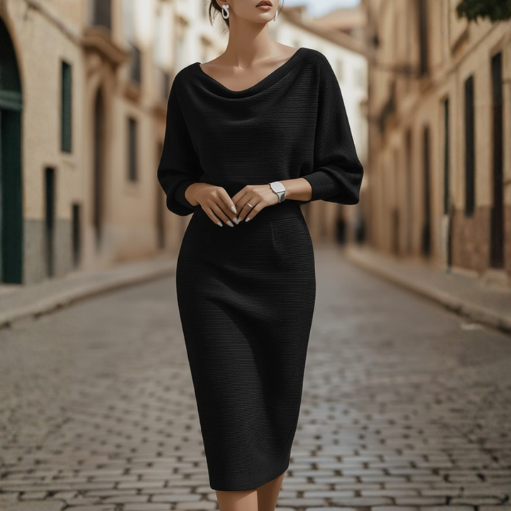 Model showcasing a batwing sleeve midi dress with a soft neckline and tailored skirt on a plain background.