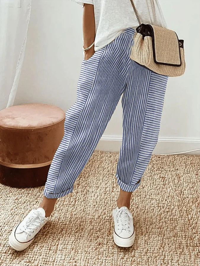 Female model wearing striped pants against a plain background.