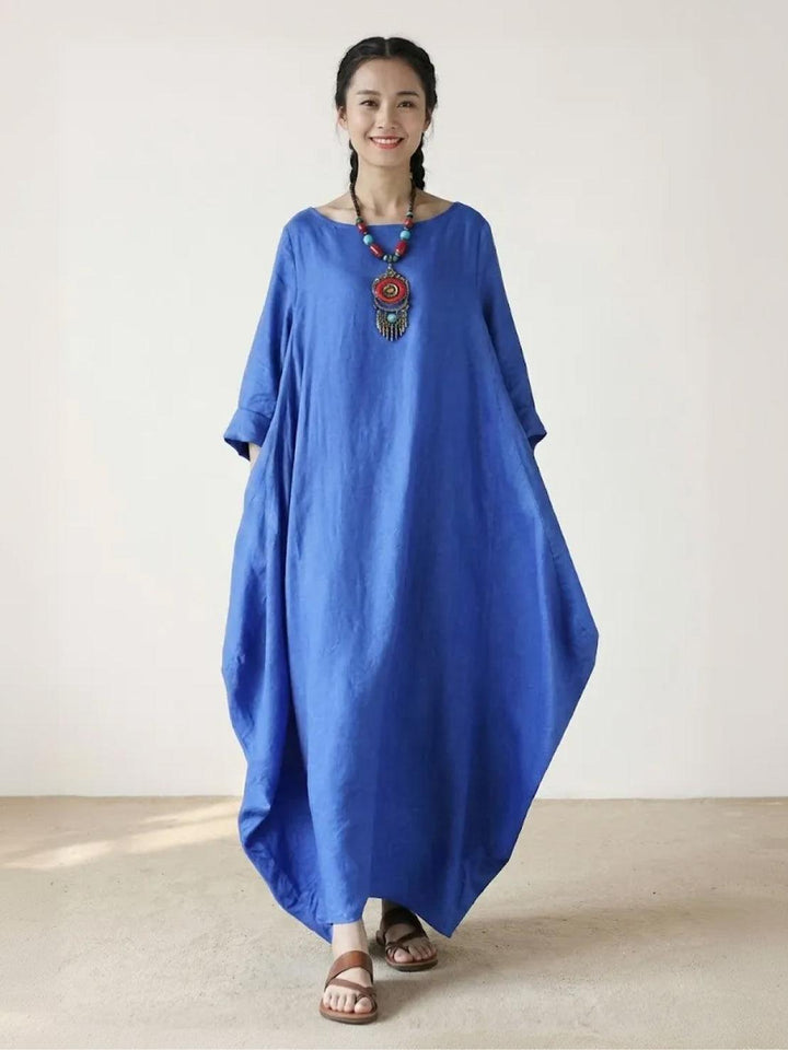 Female model wearing a loose maxi dress with 3/4 sleeves against a plain background.