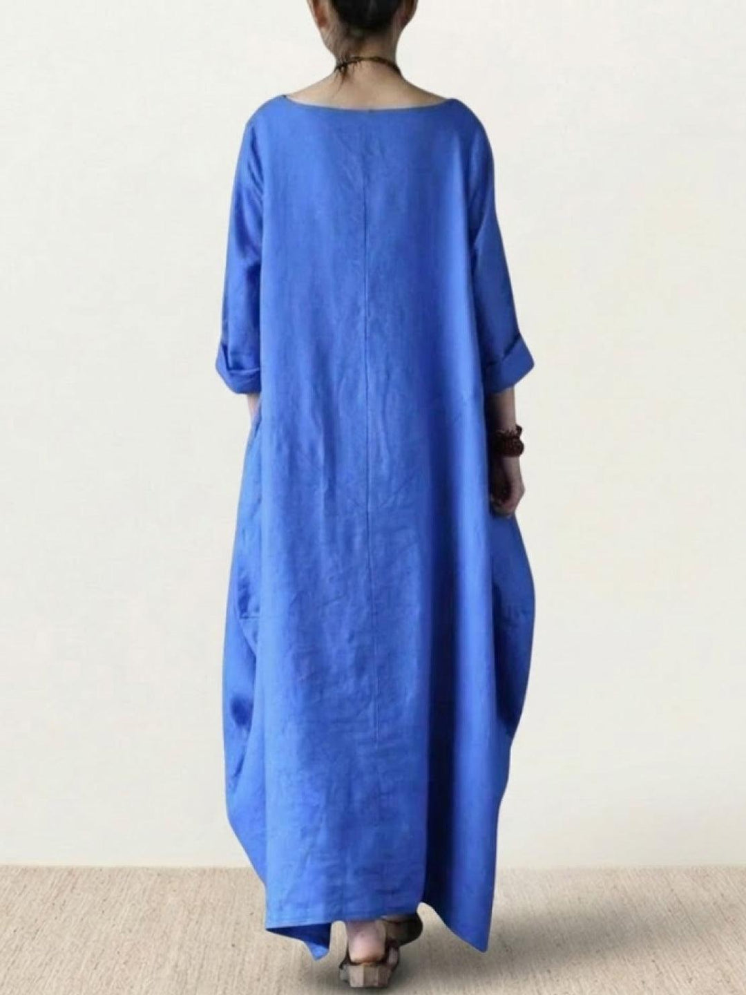 Female model standing in a relaxed silhouette dress with 3/4 sleeves.