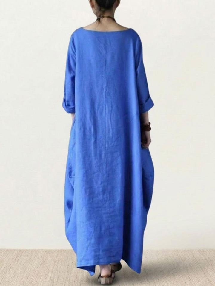 Female model standing in a relaxed silhouette dress with 3/4 sleeves.