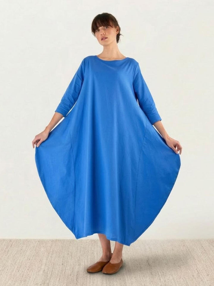 Loose-fit maxi dress styled for warm-weather fashion on a plain background.