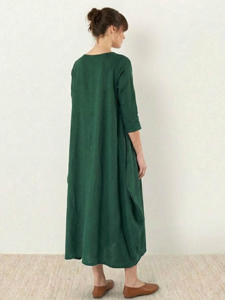 Female model wearing a relaxed-fit long dress with soft flowing shape.