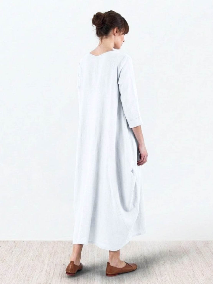 Draped maxi dress with easy styling photographed in a minimal studio setting.