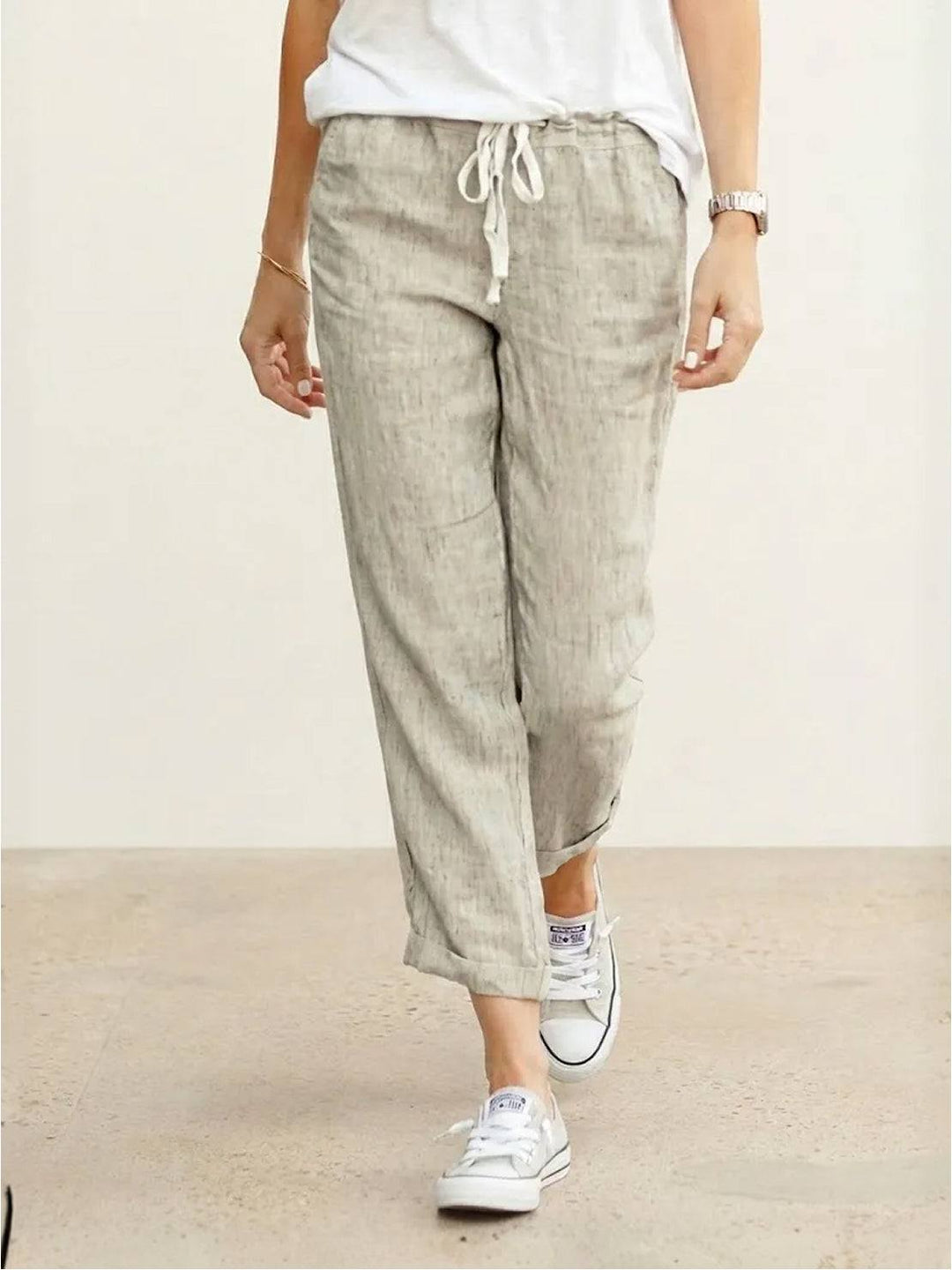 Women’s relaxed drawstring pants on a plain background with tapered legs and side pockets.