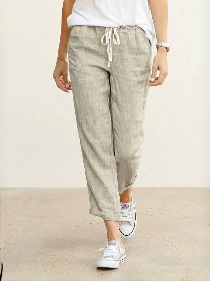 Women’s relaxed drawstring pants on a plain background with tapered legs and side pockets.