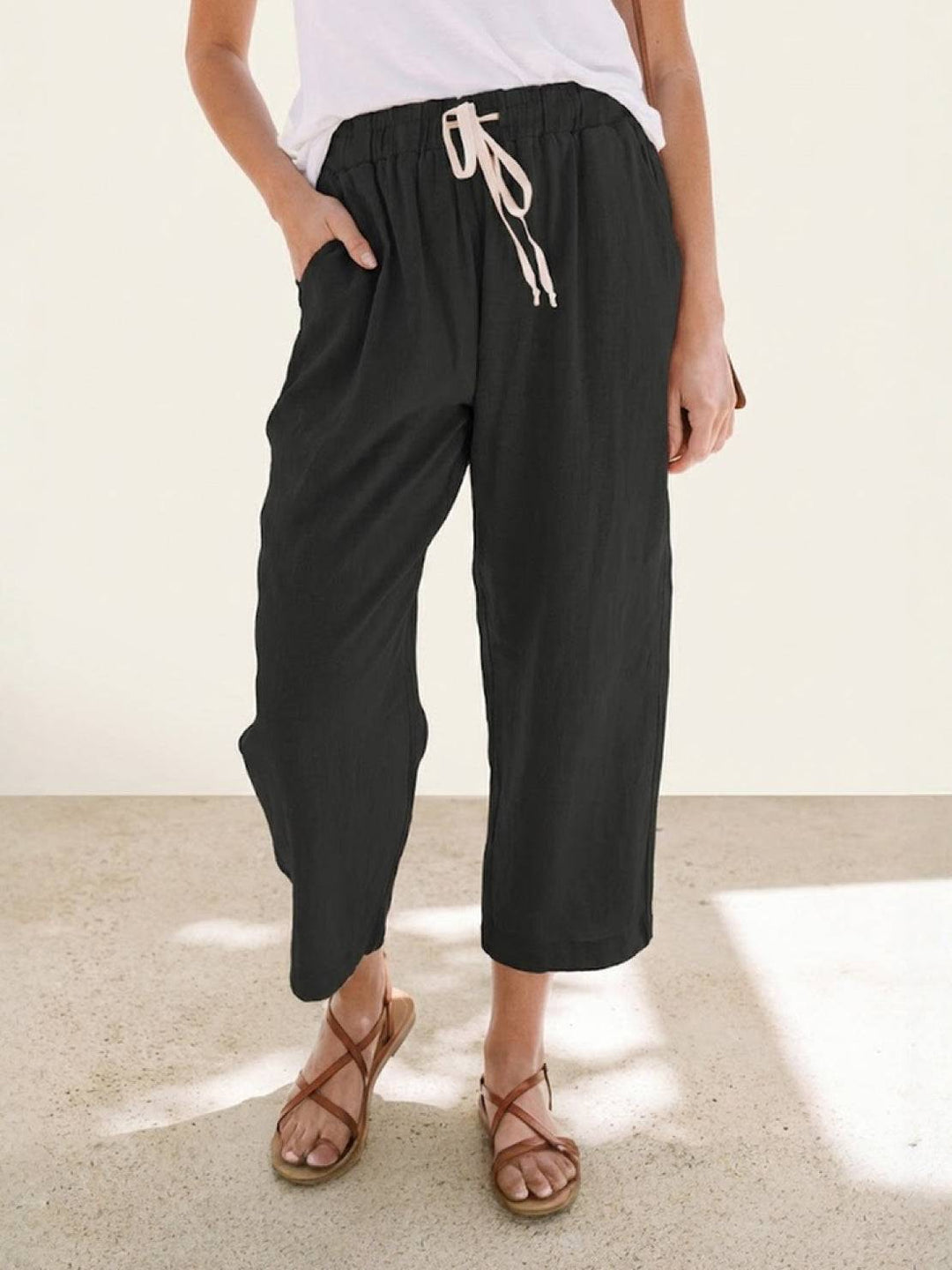 Women’s everyday drawstring trousers displayed on a plain background with a neat ankle finish.