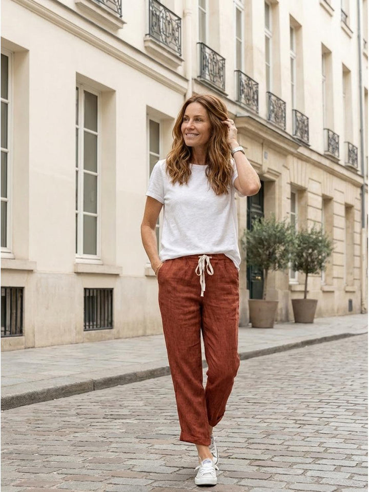 Women’s relaxed fit pants on a plain background with adjustable drawstring waist.
