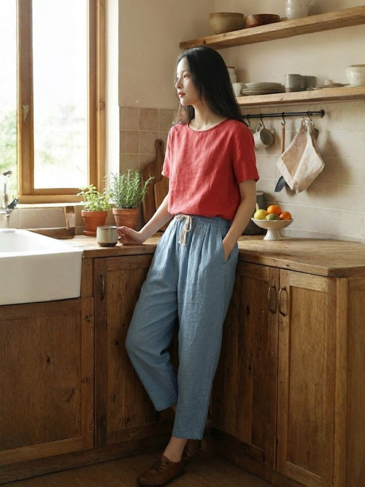 Women’s drawstring pants shown on a kitchen background with a relaxed everyday shape.