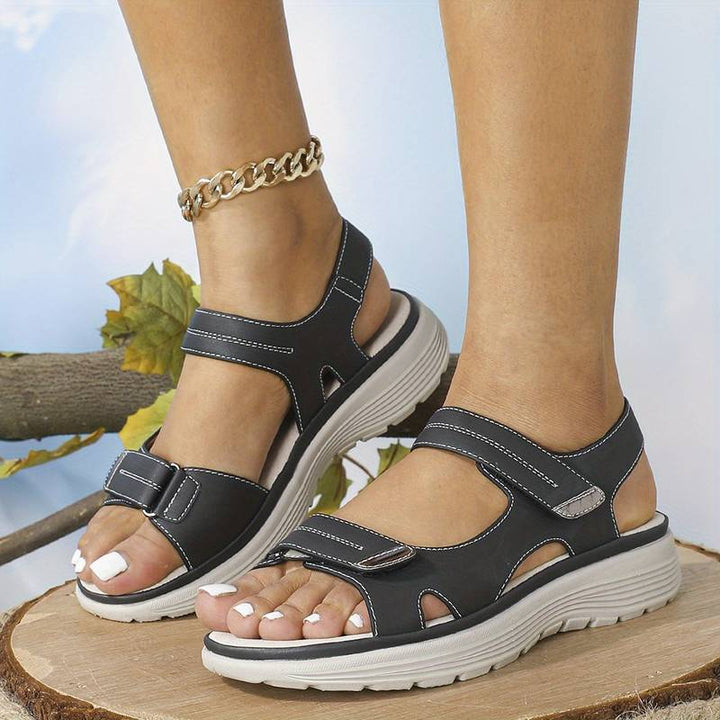 Foot wearing supportive orthopedic sandal on a plain background.