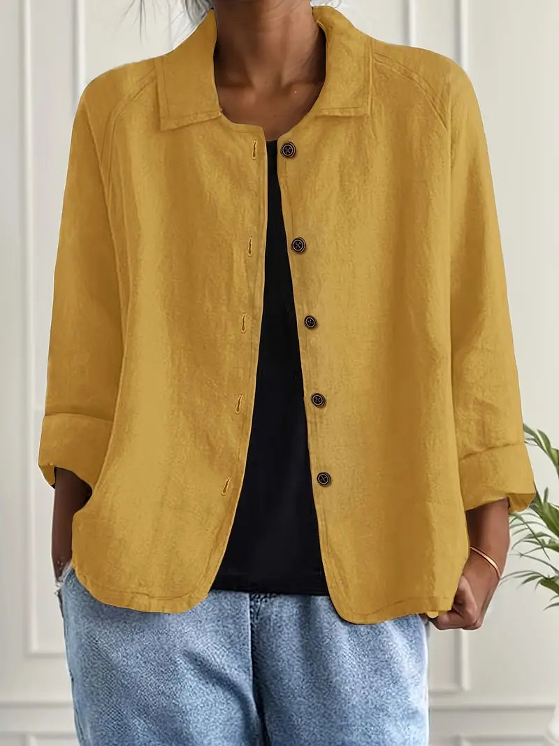 Woman wearing a minimalist top on a plain background with an effortless chic look.