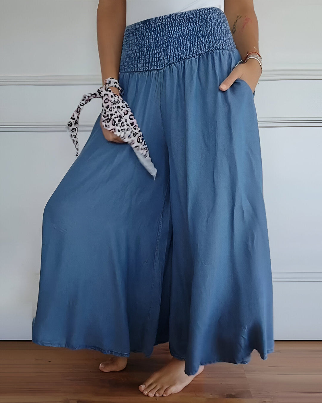 Flattering women’s pants with smooth drape on plain backdrop.