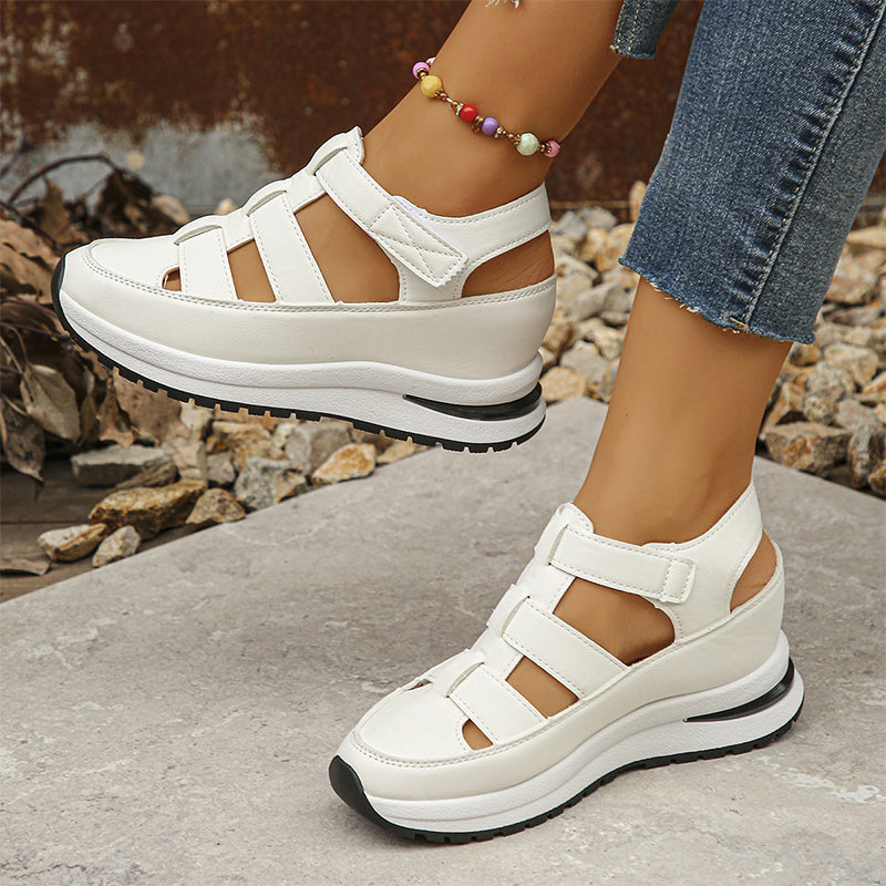 Female feet in closed-toe casual sneakers with lifted sole design.
