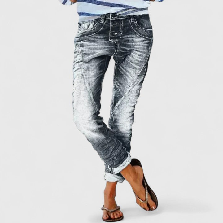 Mid-rise jeans with distressed accents on a plain background.