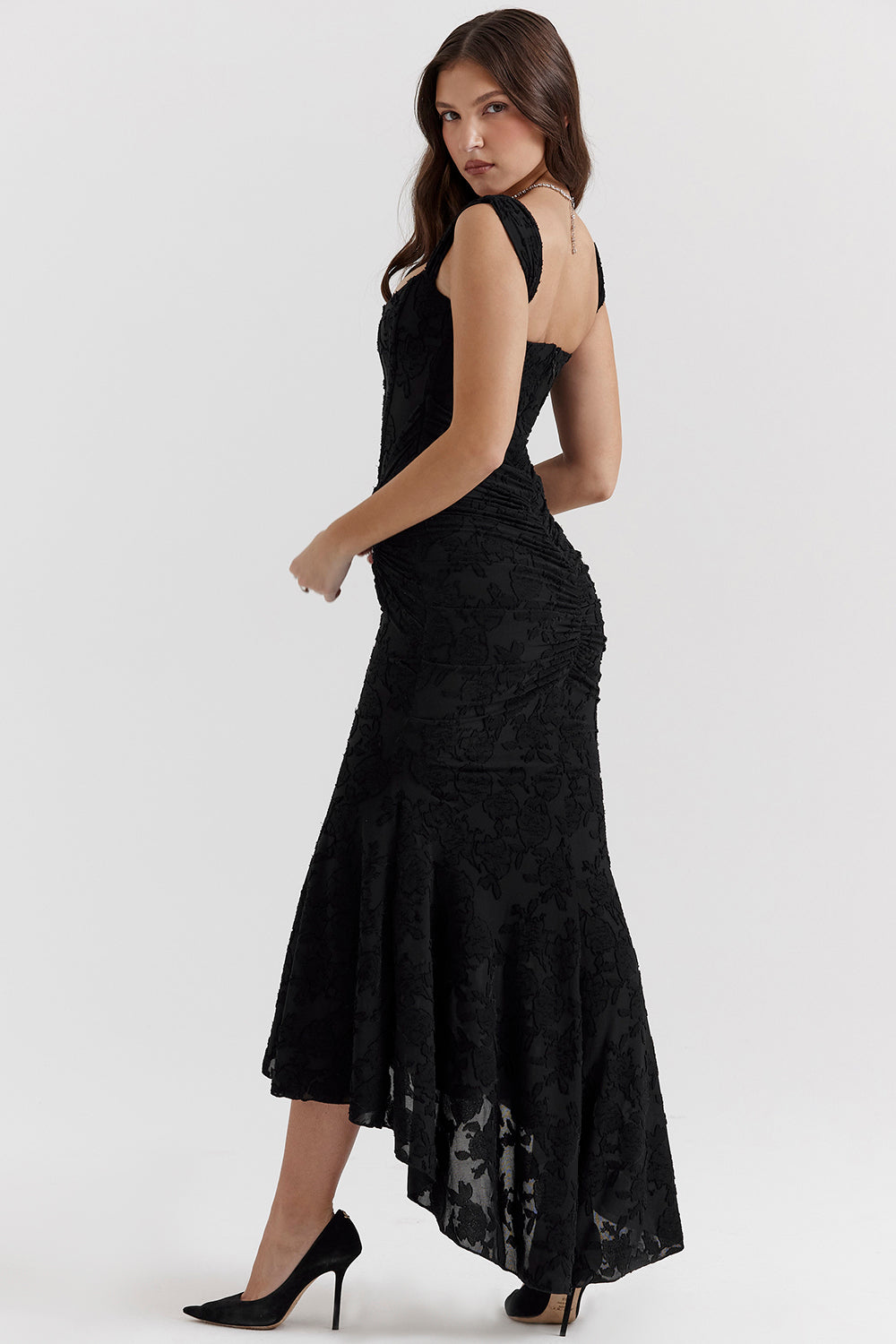 Woman modeling a sleek bodycon evening dress with gathered detailing on a clean background.
