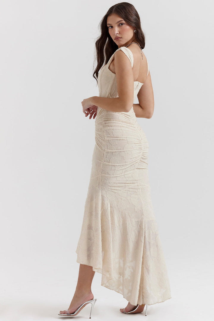 Female model styled in a ruched evening dress for special occasions against a plain background.