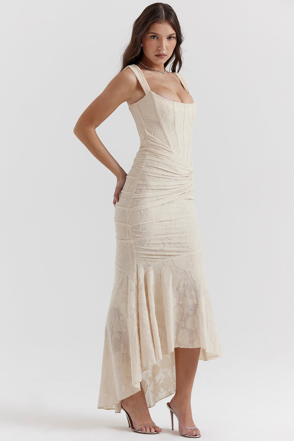 Woman in a chic sleeveless bodycon dress with ruching on a clean background.
