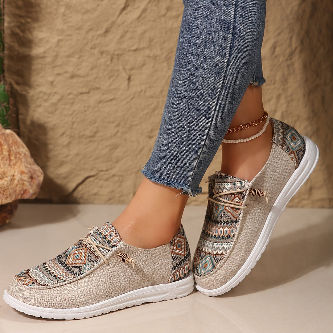 Feet styled in colorful tribal print sneakers on a clean plain background.