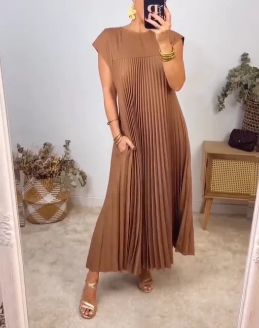 Elegant maxi dress with flowing pleats shown on a female model.