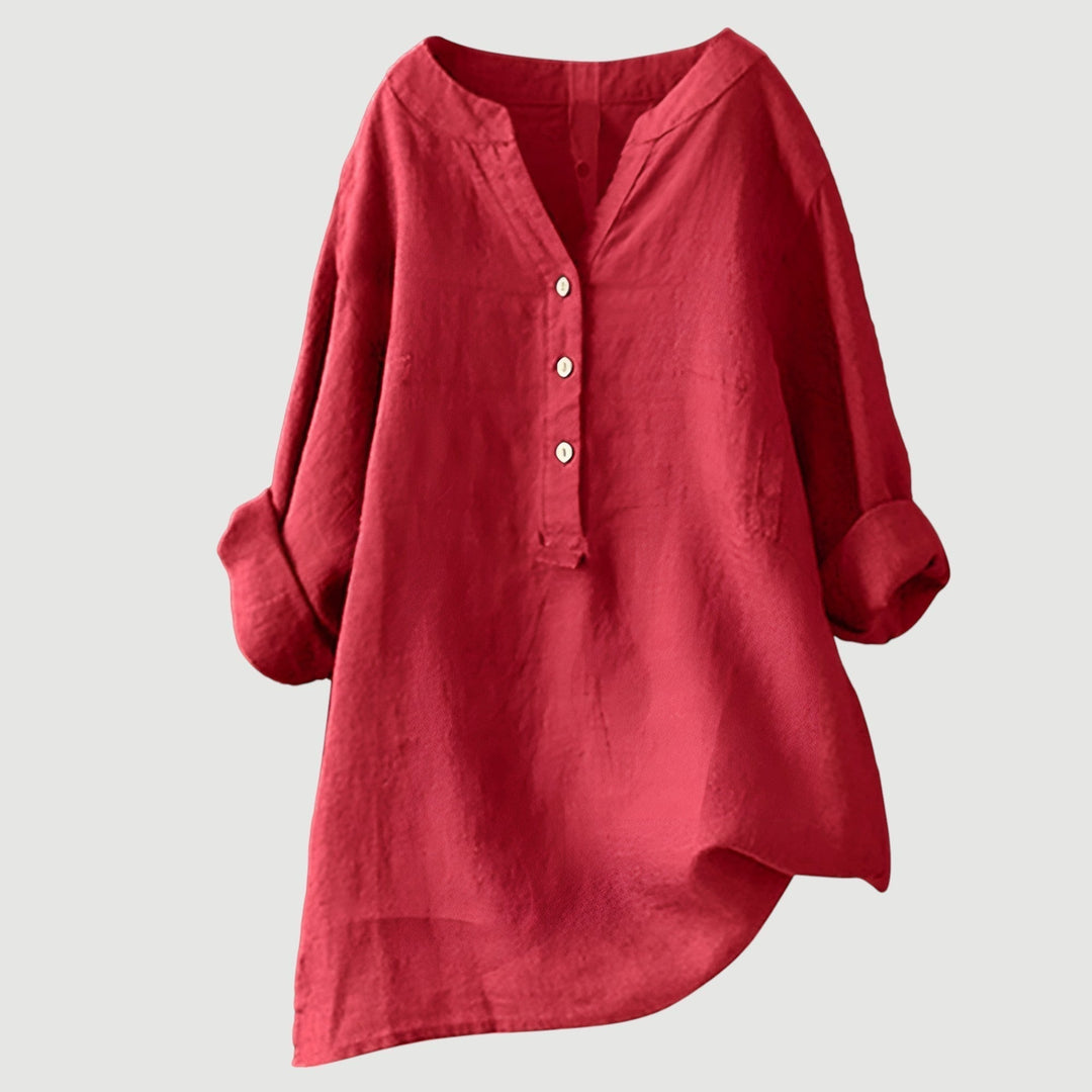 Woman wearing a flowing button tunic top against a plain background.